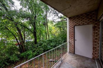a balcony with a door and some trees